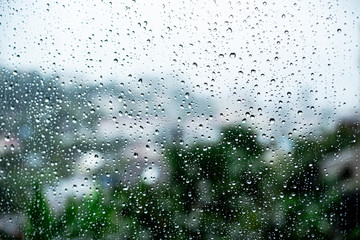 raindrops on the glass outside the window cloudy sky and greenery