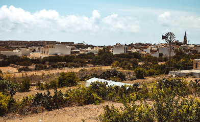 Obraz premium Hill with terraced fields for agriculture and old buildings in Ghajnsielem, Gozo island, Malta