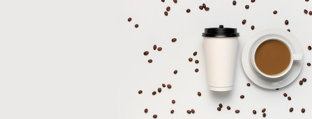 Coffee or tea paper cup, white cup with coffee, coffee beans on light gray background top view flat lay copy space. Take away coffee cup, mockup. Minimal composition, layout for design