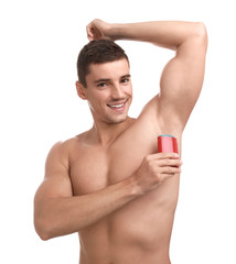 Obraz premium Young man applying deodorant to armpit on white background