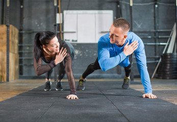 Fitness couple strengthen hands at fitness training. Man and woman working out in gym