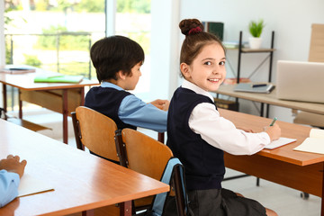 Girl wearing new school uniform in classroom