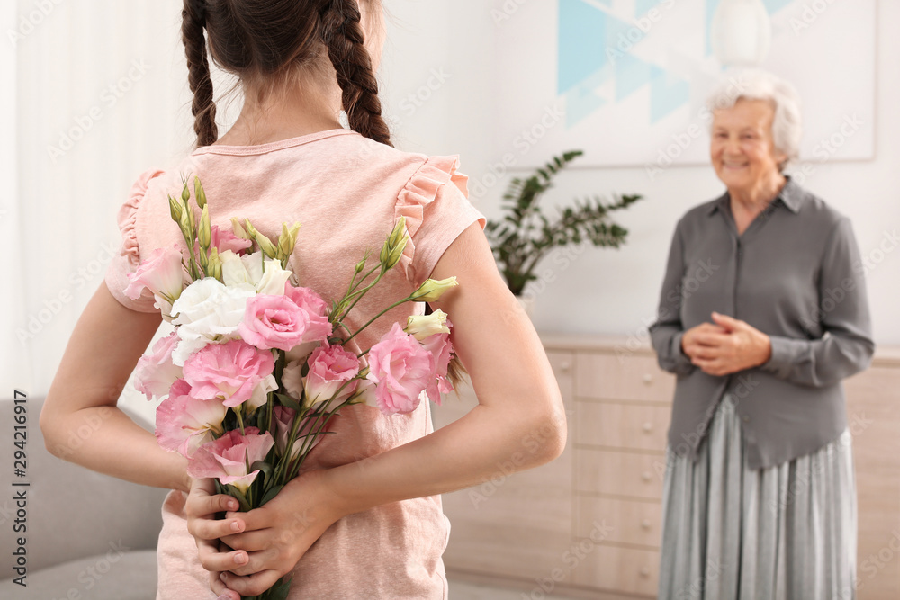 Poster Girl congratulating her grandmother at home, closeup