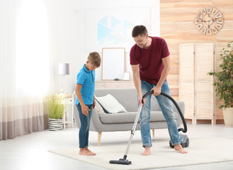 Dad and son cleaning living room together
