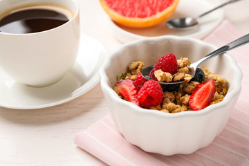 Tasty breakfast with muesli served on white wooden table