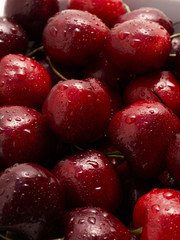 A bowl full of freshly washed cherries on white.