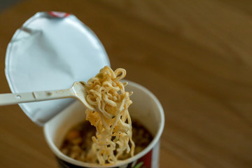 Hot noodle Cup. Noodle cup Ready made. Eating Instant Noodles with a Plastic Fork. Junk food Instant noodles are eating the popular food.