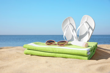 Set with stylish beach accessories on sand near sea