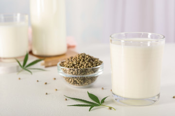 Composition with glass of hemp milk on white table indoors
