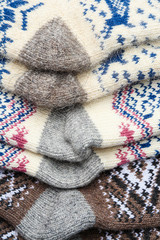 Different knitted woolen socks as background, closeup