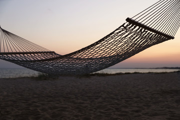 Obraz premium Empty hammock on beach at sunset. Time to relax