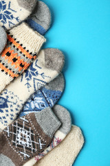 Soft knitted socks on light blue background, flat lay. Winter clothes