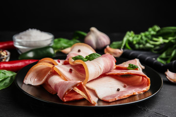 Plate with slices of raw bacon on dark table, closeup