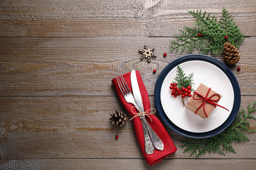 Beautiful Christmas table setting on wooden background, flat lay. Space for text