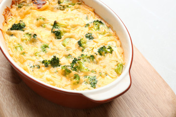 Tasty broccoli casserole in baking dish on table