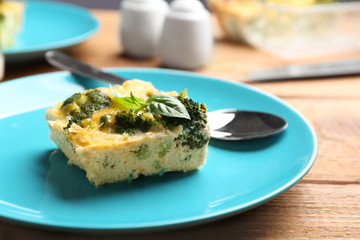 Tasty broccoli casserole served on wooden table, closeup