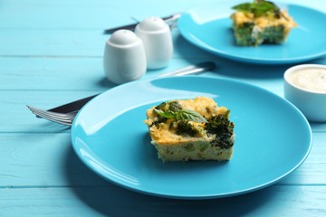 Tasty broccoli casserole served on blue wooden table