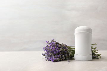Female deodorant and lavender flowers on marble table. Space for text