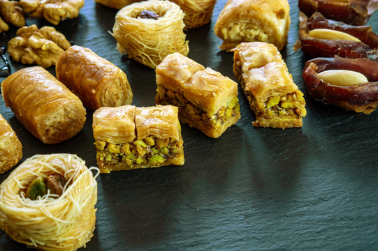 different type of arabian baklava on black background with space for text types - borma nest ush-el-bul-bul asabi