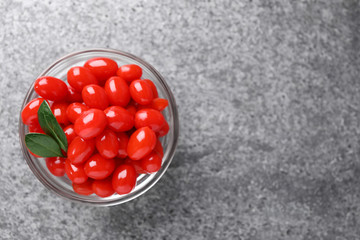 Bowl with fresh goji berries on grey background, top view. Space for text