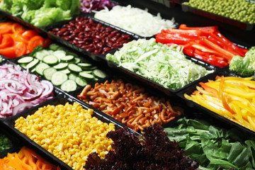 Salad bar with different fresh ingredients as background