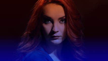Portrait of attractive young woman with curly red hair and glamour makeup, image with soft dark blue gradient
