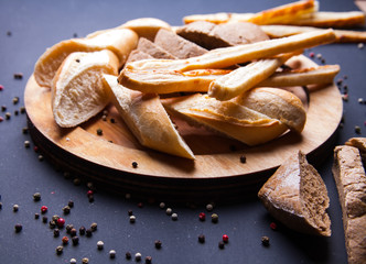Sliced slices of black fresh rye bread on a round plate