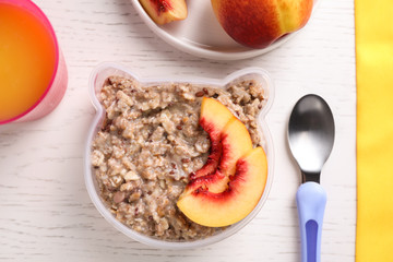 Flat lay composition with oatmeal on white wooden table. Breakfast for kids