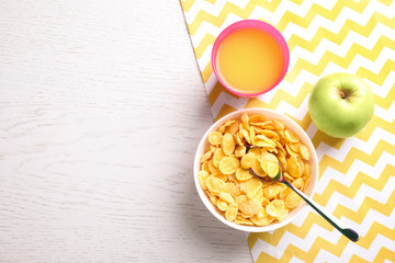 Flat lay composition with cornflakes on white wooden table, space for text. Healthy breakfast