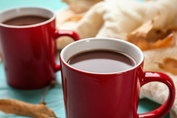 Cups of hot drink on table, closeup. Cozy autumn atmosphere