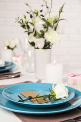 Elegant festive table setting with blank card in restaurant