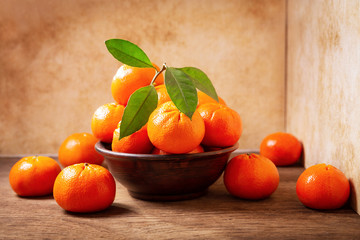 Fototapeta na wymiar Fresh mandarin oranges fruit or tangerines with leaves in a bowl