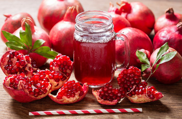 glass jar of pomegranate juice with fresh fruits