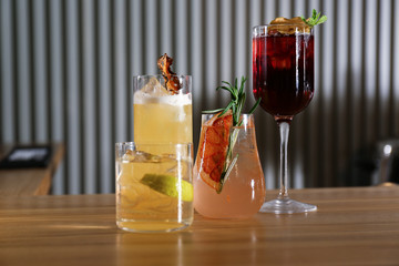 Glasses of delicious cocktails with vodka on wooden counter in bar