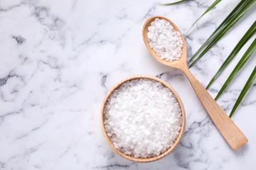 Flat lay composition with white sea salt on marble background, space for text. Spa treatment