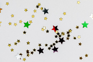 color confetti in shape of stars on white background, close up