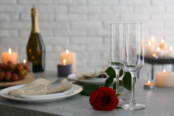 Romantic table setting with burning candles indoors
