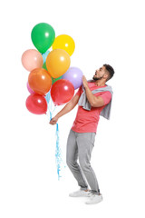 Emotional young man holding bunch of colorful balloons on white background