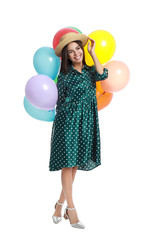 Young woman holding bunch of colorful balloons on white background