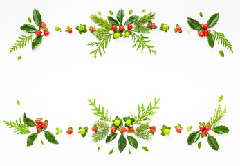 Christmas composition  with branches of spruce and holly with red berries on white background. Merry christmas greeting card with empty space for holiday text.