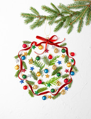Christmas composition  with red ribbon ,branches of fir tree and Christmas ornaments in shape of Christmas bauble on white background. Merry christmas greeting card with empty space for holiday text.