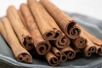 Winter food ingredient, dried aromatic cinnamon sticks on tin plate