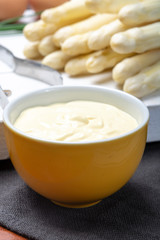White hollandaise sauce in bowl, traditional sauce for dishes with cooked white asparagus