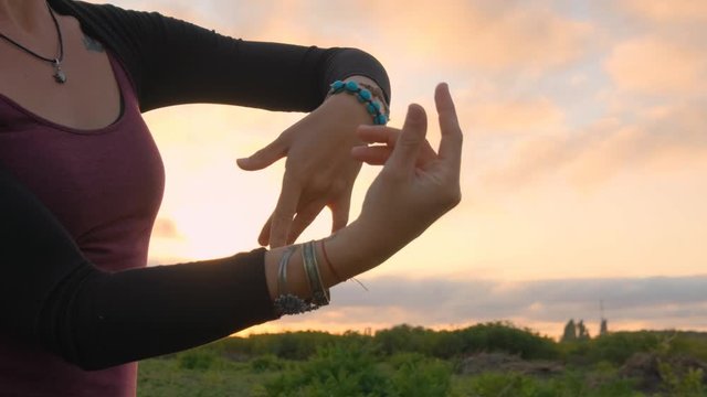 Close up hands and fingesr of dancing woman during the sunset