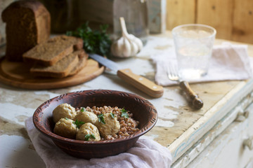 Meatballs in sour cream sauce, served with buckwheat porridge, bread and garlic. Rustic style.