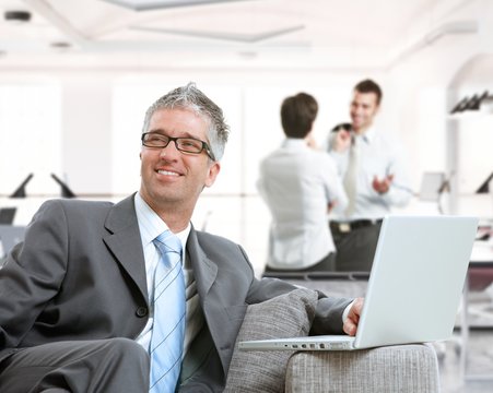 Happy businessman working with laptop