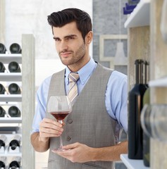 Young man holding glass of red wine