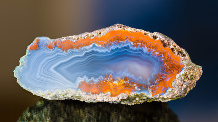 Cross-section by polished agate with beautiful wavy pattern on smooth cut surface. Blue gem detail...