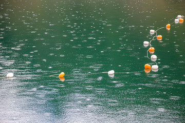 Rope with white and yellow restriction markers on water surface for prohibiting of swimming in deep...