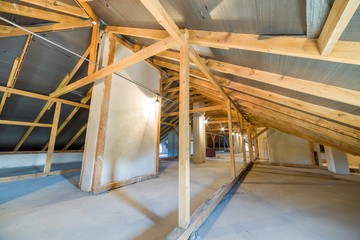 Attic of a building with wooden beams of a roof structure.